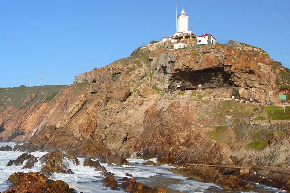 The Cape St Blaize lighthouse and cave headland above the surf at Mossel Bay.