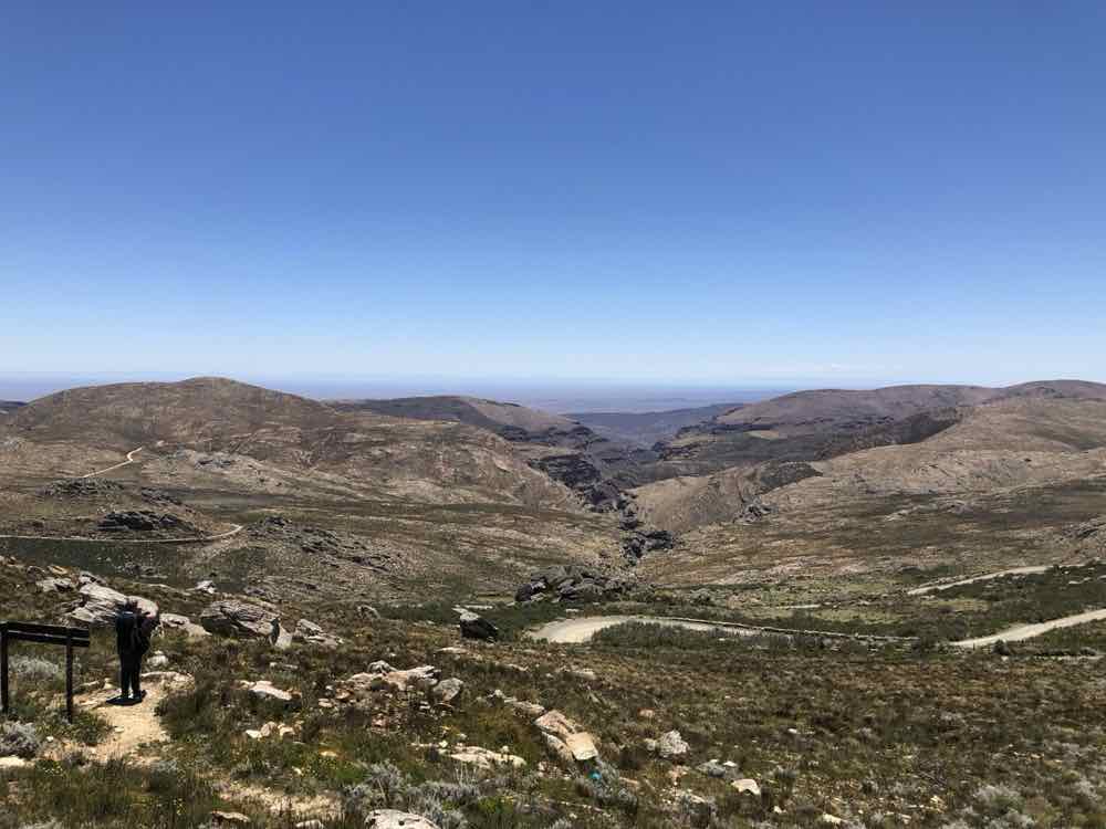 A gravel mountain-pass road winding through the folded rock of the Great Karoo.